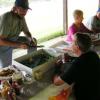 Pictured is Secretary Mark Lewis talking to club member Ryan Harmon as he is cutting another piece of cake for someone.