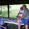 After a morning of bass fishing the club members talk about thier day on the water before the picnic food is ready to eat.