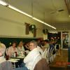 Everyone is enjoying light conversation after dinner and some are reading over the banquet news.